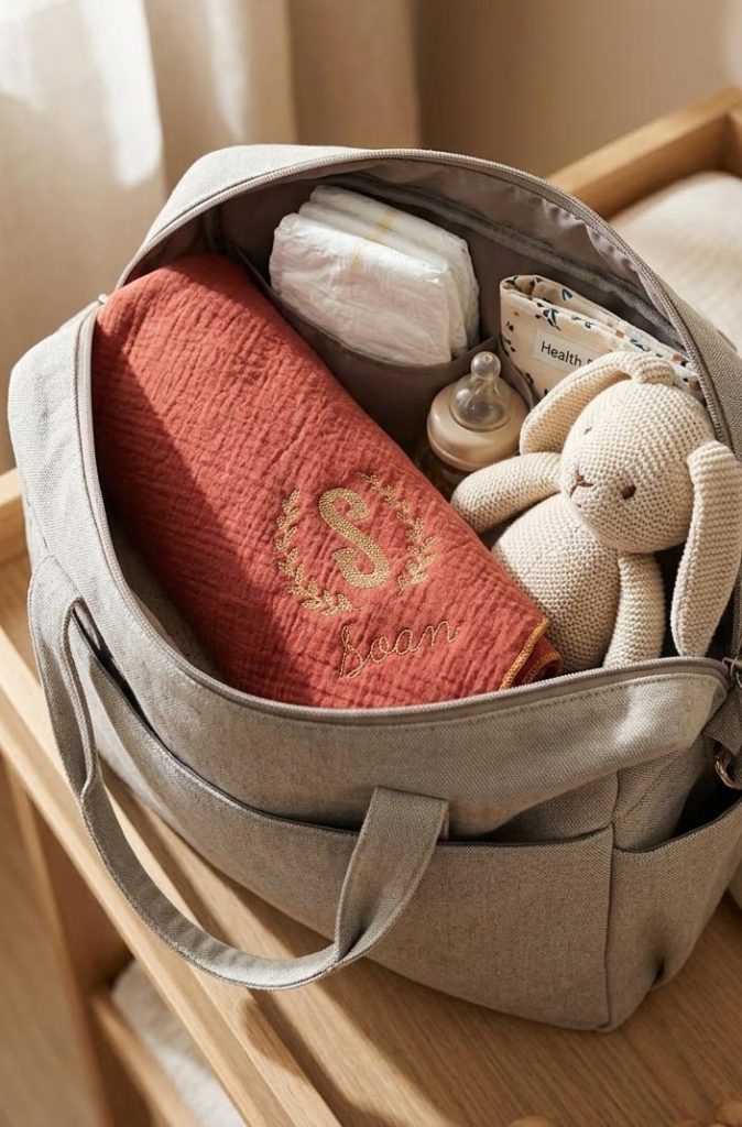 lange bébé de couleur rouille rangé dans la valise de maternité